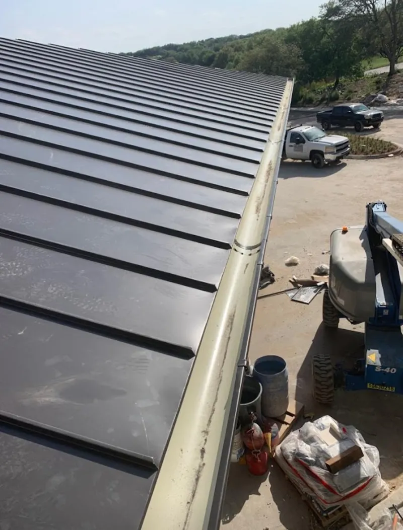 Standing seam panel and gutter detail on a metal roofing jobsite in Goddard